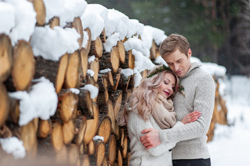 A couple in love warms and hug each other. Winter wedding. Groom tenderly kissed his bride in her temple