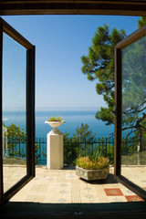 The window offers a view of the blue sea