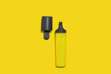 new yellow bright plastic marker lying on a yellow background with an opened cap. concept of office supplies
