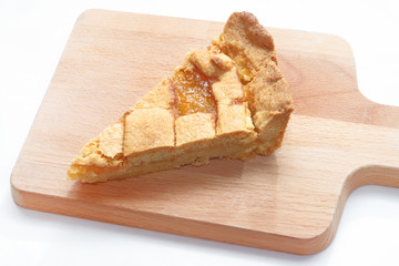 SLICE OF A LEMON JAM CAKE ON A CUTTING BOARD ON WHITE BACKGROUND