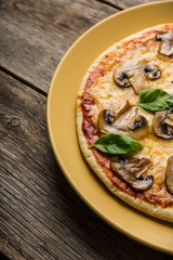 Freshly making pizza with mushrooms served on the rustic background. Selective focus. Shallow depth of field.
