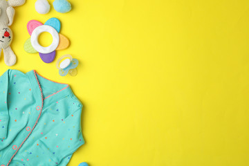 Flat lay composition with child's clothes and accessories on yellow background, space for text