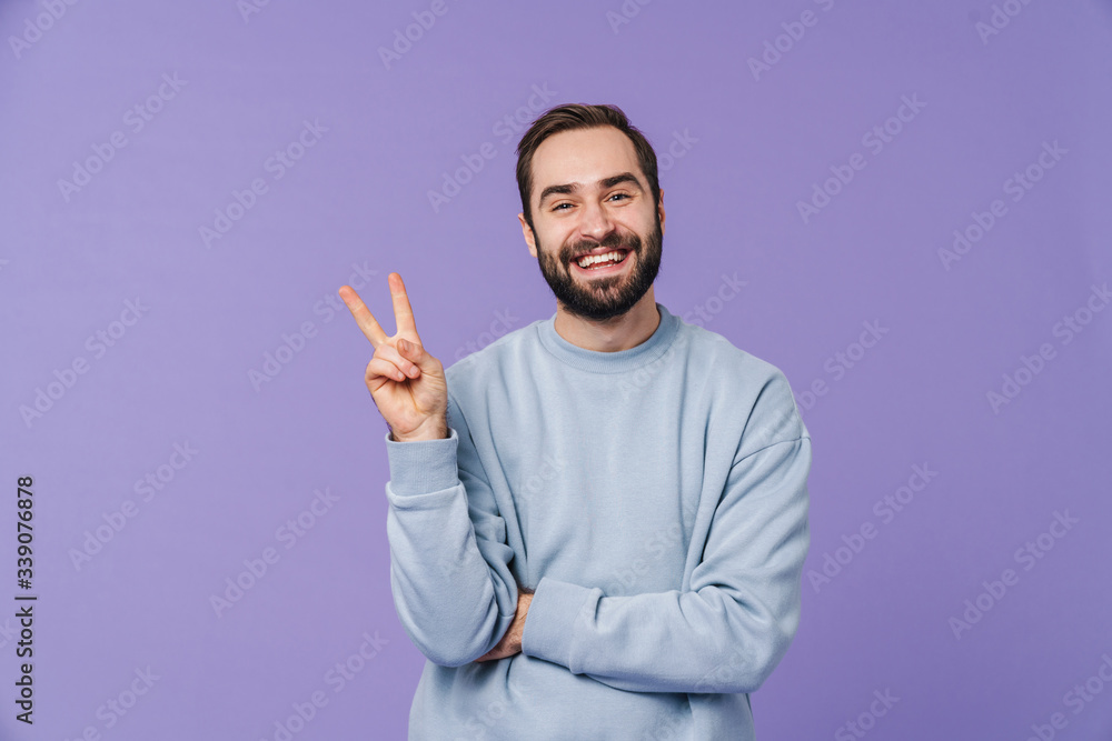 Canvas Prints Positive happy young man showing peace gesture.