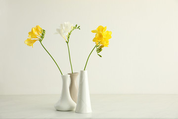 Beautiful freesia flowers on white marble table