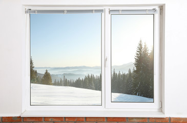 Beautiful view of snowy forest through big window