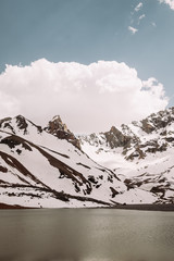 Tajikistan. Fann mountains Summer. The mountain is almost completely covered by snow and the lake. mountain landscape. Vertical photography