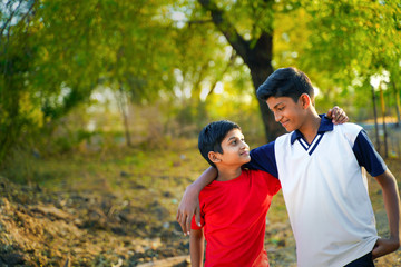 two little indian brother walking on road