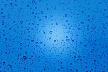 Different water droplet on glass with blue background