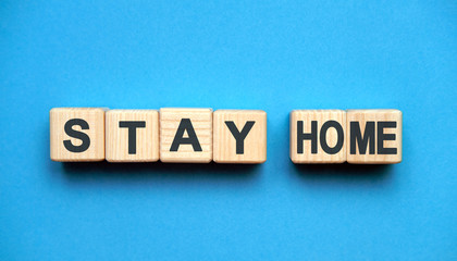 Stay home text on wooden blocks, medical concept, blue background