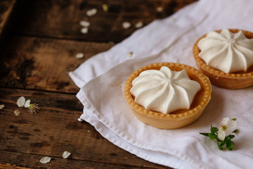 lemon cheesecake pie on wooden background with flower petals
