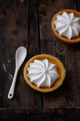 lemon cheesecake pie on wooden background with flower petals