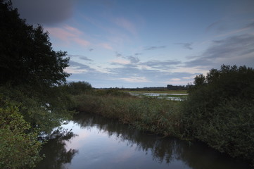 Meadows and river in the evening, at sunset time