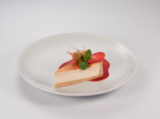 cheesecake with berries and mint leaf on a white background