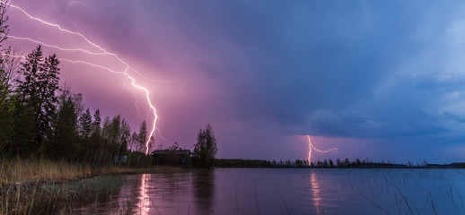 Lightning reflected on a lake during a thunderstorm in Finland