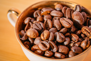 Coffee beans in cup on wooden table