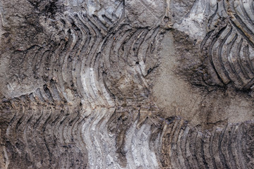 The texture of grey concrete, the trail from the fallen off tiles of dark gray color, mesh structure, pieces of concrete