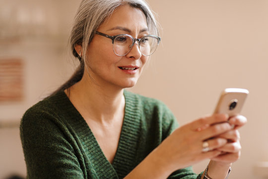 Mature Beautiful Grey-haired Woman Using Mobile Phone.