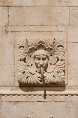 Amazing Onophrian Fountain gargoyle with water spout from the mouth the old town of Dubrovnik Croatia Water flowing down