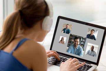 View over woman shoulder resting at home using computer, pc screen view diverse girls and guys...