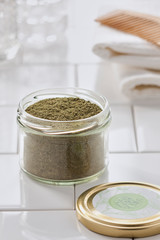 ground herbs in a jar on a white background