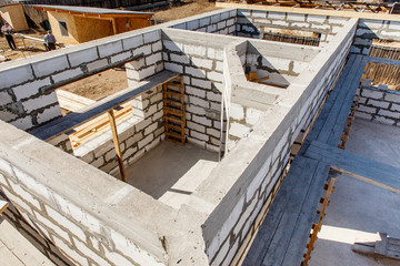 Under construction house walls made from white aerated autoclaved concrete blocks. Woods elements and components of the construction of roof. Ceiling beams of natural eco-friendly materials. top view