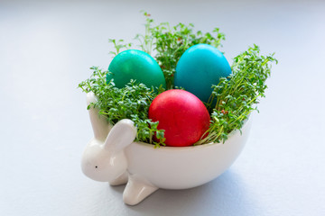 Painted Easter eggs in a bowl with cress