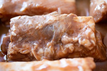 Raw marinaded juicy pork ribs ready for cooking. Meat processing picture. Food photography close up background