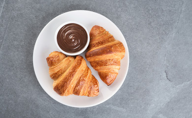 Croissants and chocolate butter on a gray background.