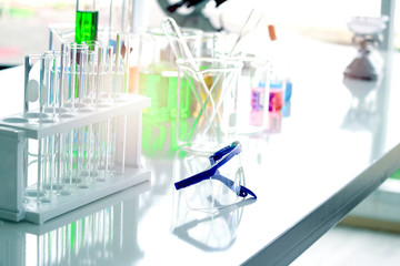 Safety glasses goggles and scientific glassware for doing science experiment, biology and chemistry lab, laboratory research concept