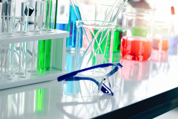 Safety glasses goggles and scientific glassware for doing science experiment, biology and chemistry lab, laboratory research concept