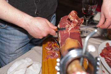  butcher cuts meat with knife for party