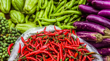 Close up of fresh and red chilli and other exotics vegetables for sale on an asian street market