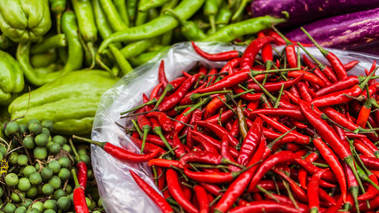 Close up of fresh and red chilli and exotics vegetables for sale on an asian street market
