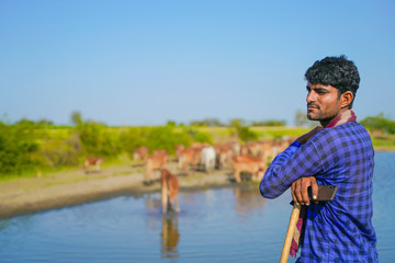 young indian farmer with his cattle
