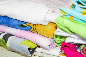 Colorful bed linen in the closet on the shelf