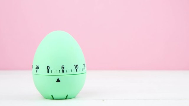 4K blue kitchen egg timer on a pink background. cooking time, soon Easter. horizontal, copy space