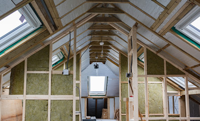 Loft conversion, unfinished project, silver insulation, roof windows, wood structure of the walls, selective focus