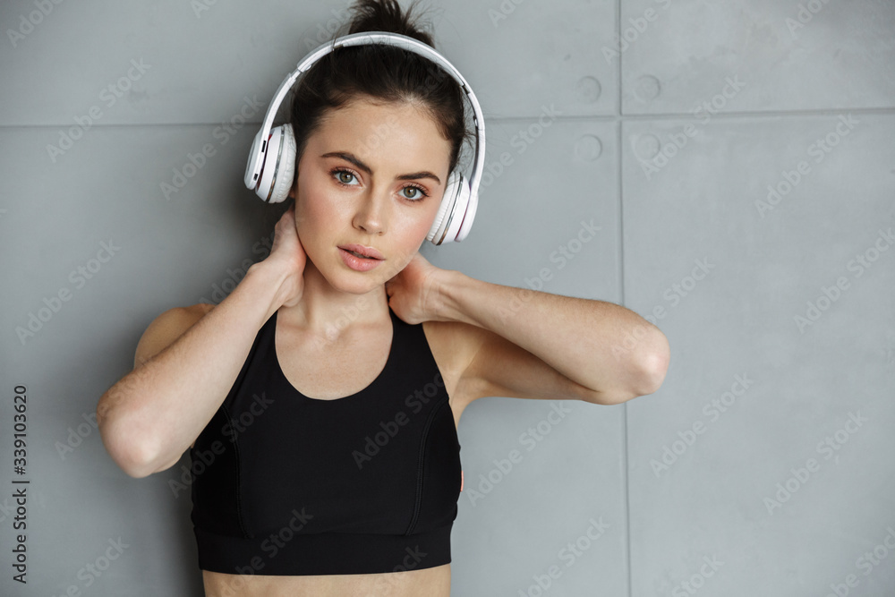 Sticker photo of nice seductive woman in sportswear using headphones