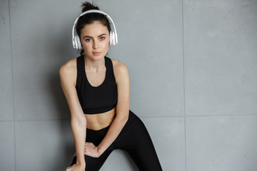Photo of nice seductive woman in sportswear using headphones