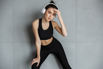 Photo of nice seductive woman in sportswear using headphones