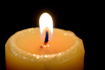 close up burning candle on black background