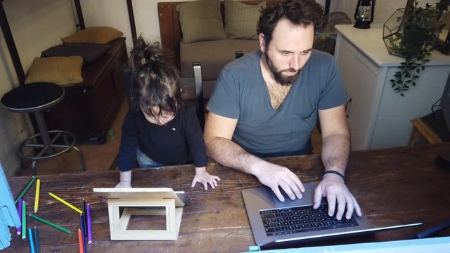 father and daughter using a laptop and tablet at home during the lockdown for covid 19