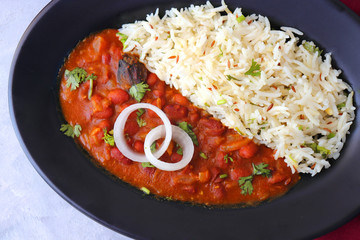 Rajma Chawal is a popular North Indian Food. Rajma is a socked Red kidney beans cooked with onions, tomatoes and a special blend of spices. Served with Jeera rice or Cumin Rice. With Copy Space.