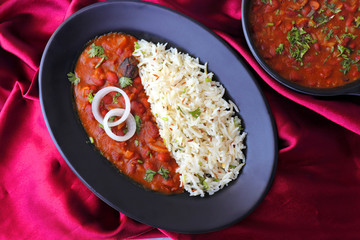 Rajma Chawal is a popular North Indian Food. Rajma is a socked Red kidney beans cooked with onions, tomatoes and a special blend of spices. Served with Jeera rice or Cumin Rice. With Copy Space.