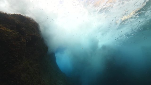 underwater scenery of rock splash foam and waves on surface slow ocean scenery 