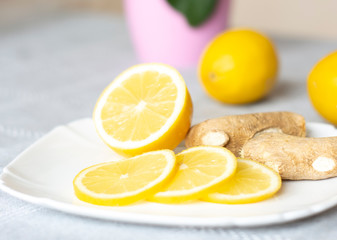 Fototapeta na wymiar Ginger and lemon on a plate. Increased immunity. Natural vitamins. Close-up