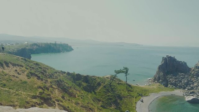 Aerial View of the Baikal Bay Shamanka. White ship in calm bay at great lake. Olkhon Island, Baikal, Russia, Siberia. Drone footage. UNESCO World Heritage Site
