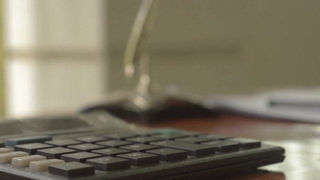 Close up of a calculator placed on office desk. Out of focus loan application form at a distance. Business Finance Concept. Vintage background. Isolated. Copy space room for text.