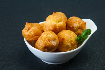 Sweet tasty profiteroles heap in the bowl