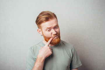 bearded man put his finger to his cheek